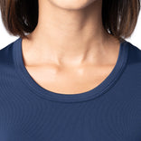 Close-up of a person wearing a navy blue shirt with a plain background