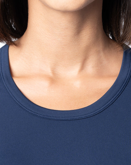 Close-up of a person wearing a navy blue shirt with a plain background